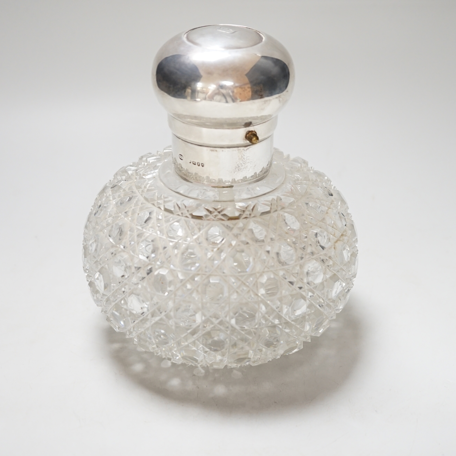 A large Victorian silver mounted globular cut glass atomiser, the lid with pump action button, the body with hobnail cutting, makers initials GB, London 1881, height 16.5cm